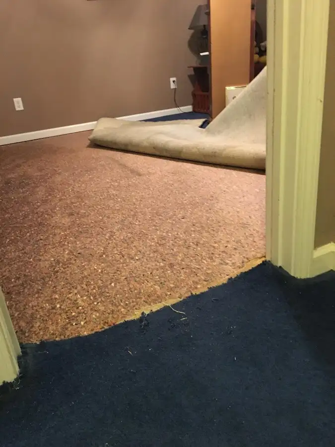 Carpet pad removal revealing water damage during Water Mitigation Services in Hudsonville